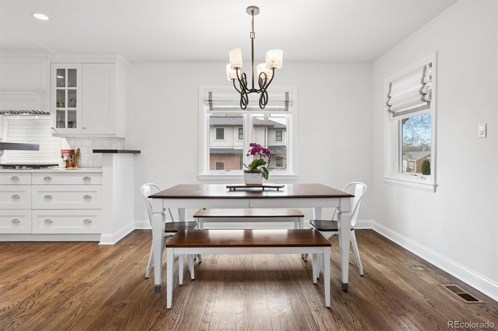 2700 Stuart Street Denver, CO 80212 - Photo 5 of 49 a view of a dining room with wooden floor a chandelier a wooden table and chairs