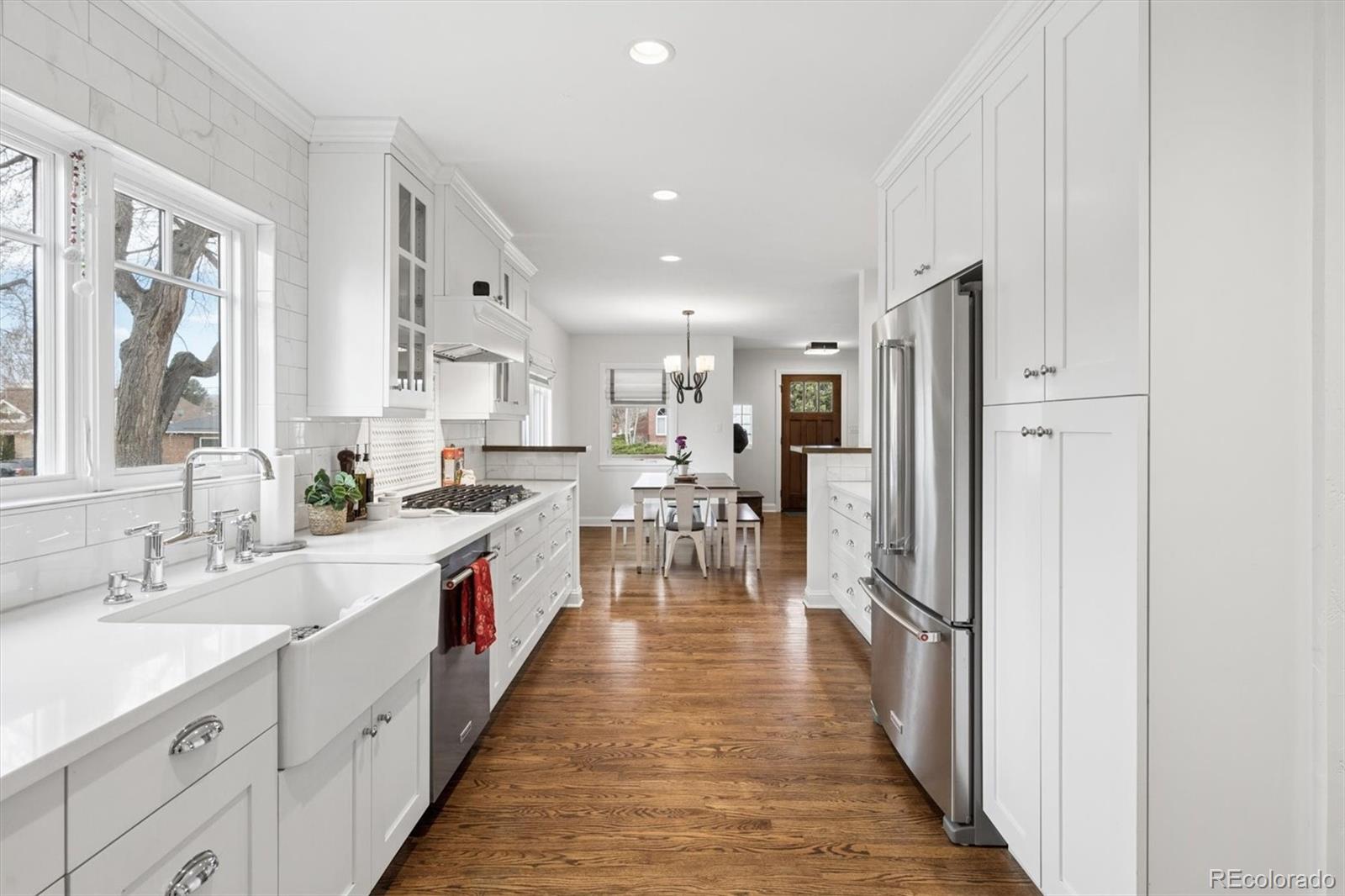 2700 Stuart Street Denver, CO 80212 - Photo 8 of 49 a large kitchen with stainless steel appliances a large counter top a stove a chimney a sink and a refrigerator
