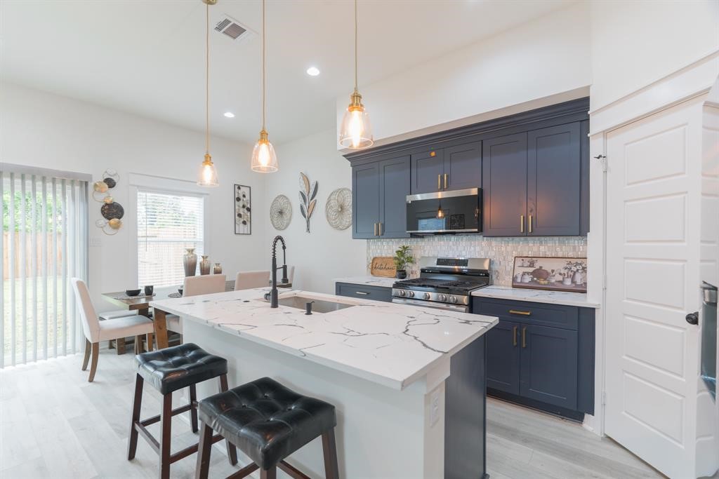 890 Lucky Street, Unit A Houston, TX 77088 - Photo 11 of 48 a kitchen with a stove a sink a dining table and chairs