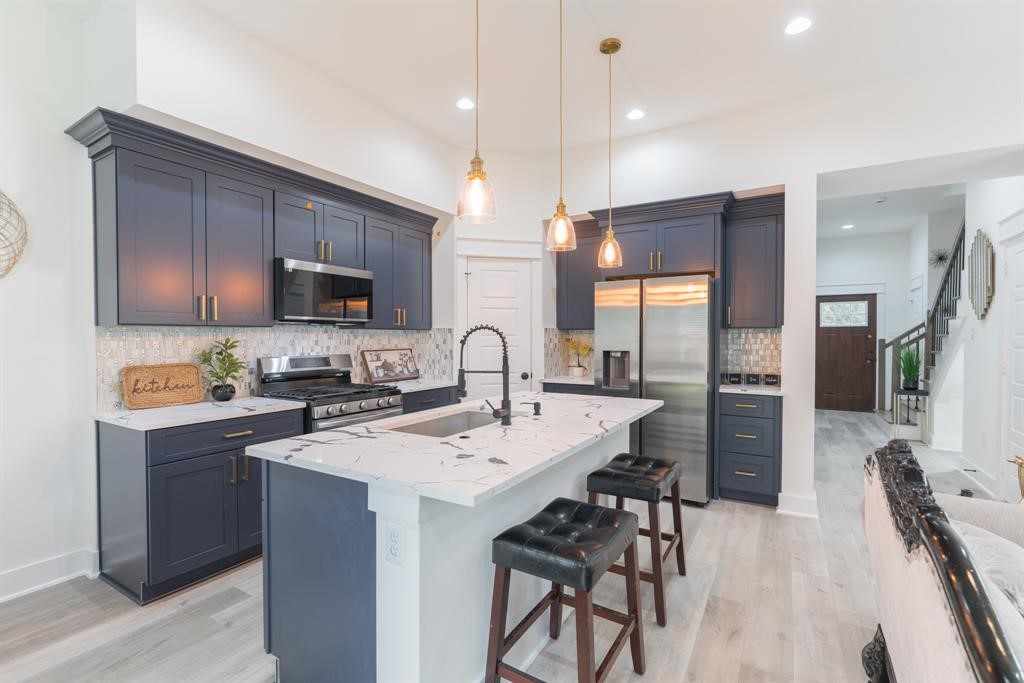 890 Lucky Street, Unit A Houston, TX 77088 - Photo 13 of 48 a kitchen with a sink a center island a stove cabinets and a dining table