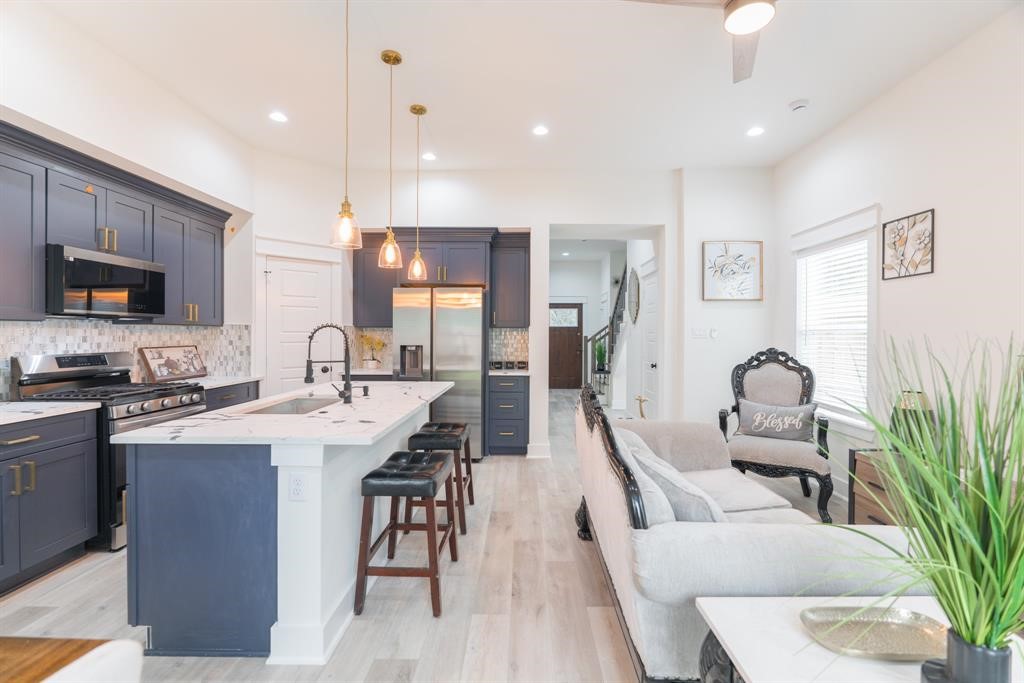 890 Lucky Street, Unit A Houston, TX 77088 - Photo 9 of 48 a very nice looking open dining room with kitchen island stainless steel appliances furniture a fireplace and a chandelier