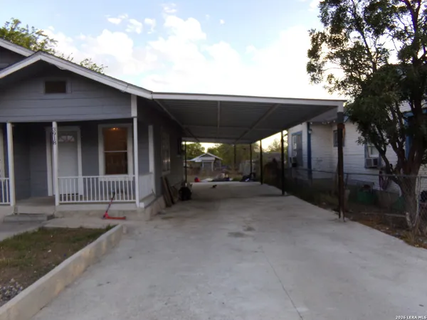 a view of a house with a small yard and fence