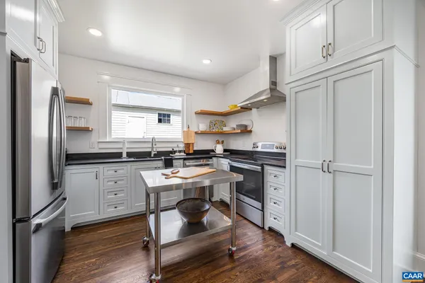 a kitchen with stainless steel appliances a sink a stove and a cabinets