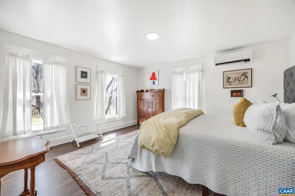 a bedroom with a bed and a painting on the wall