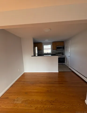 a view of a kitchen with wooden floor and a sink