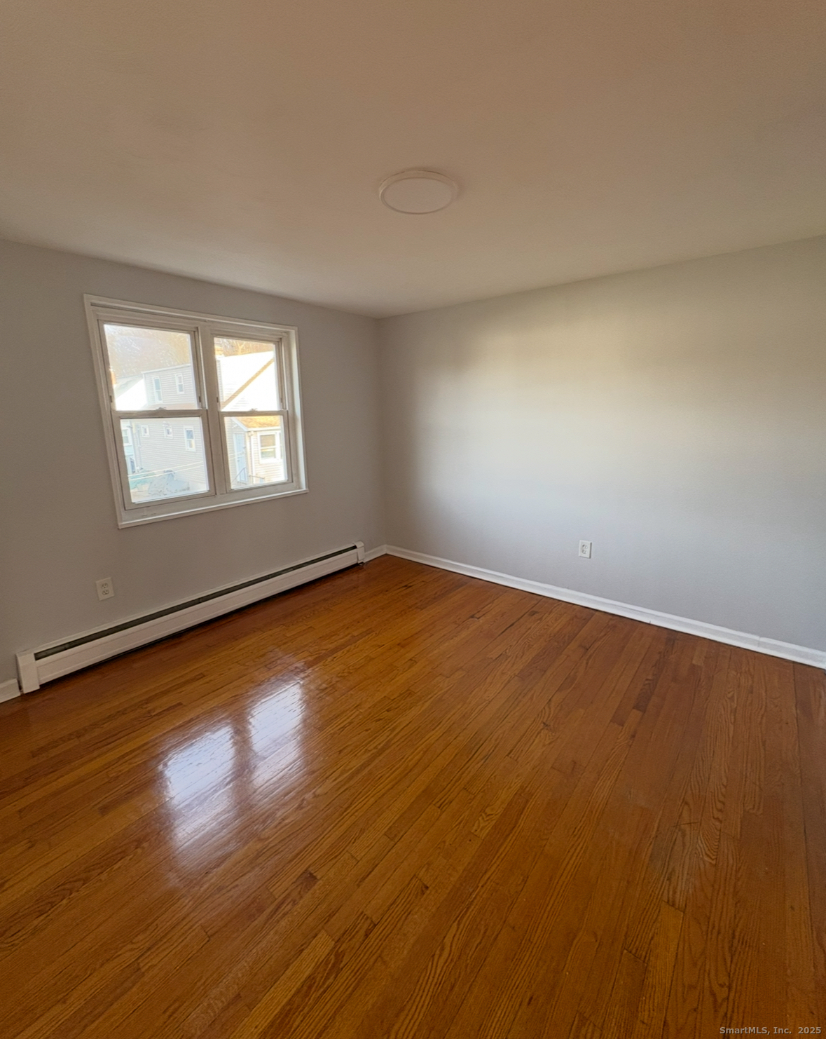 554 Eastern Street, Unit 3 New Haven, CT 06513 - Photo 5 of 5 an empty room with wooden floor and windows