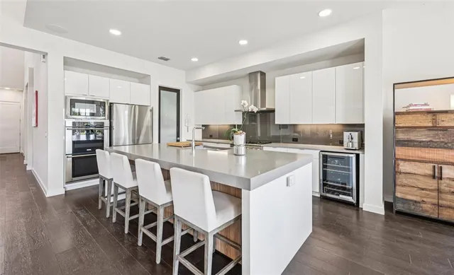 a kitchen with a dining table chairs refrigerator and cabinets