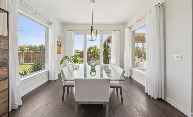 a view of a dining room with furniture a chandelier and wooden floor