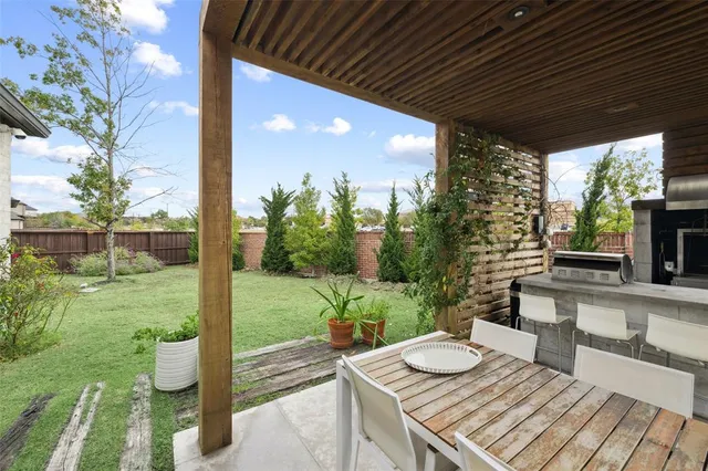 a view of a backyard with table and chairs and potted plants