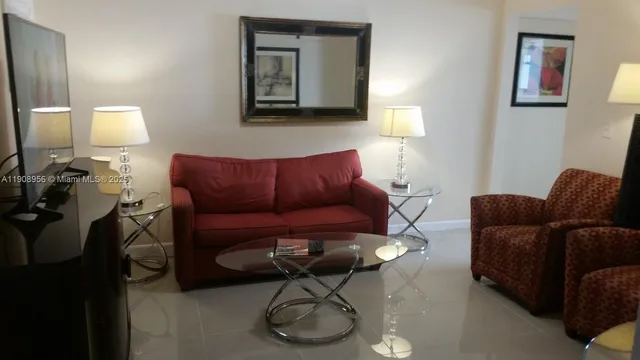 a living room with furniture a couch and a lamp