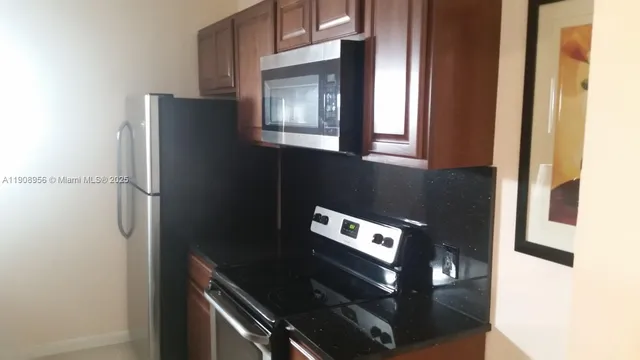 a close view of a refrigerator a stove and cabinets