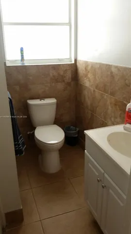 a bathroom with a toilet a sink and a window