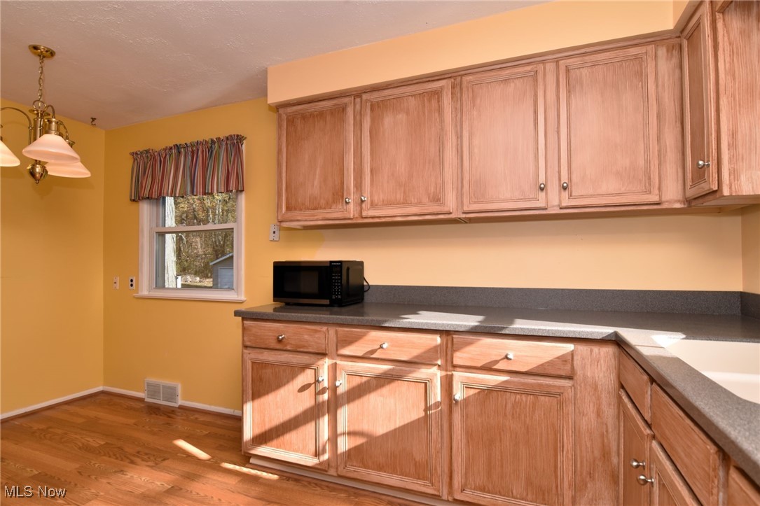 38535 Aurora Road Solon, OH 44139 - Photo 10 of 26 Kitchen with a notable chandelier, decorative light fixtures, and wood-type flooring