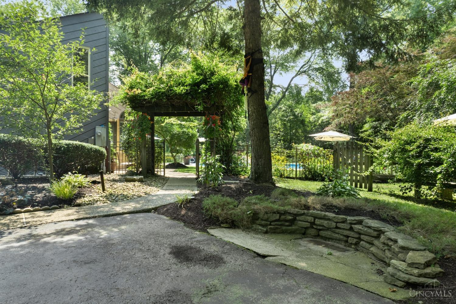 524 Chapel Road Amelia, OH 45102 - Photo 42 of 56 As you pull up to the home, this beautiful wisteria arch leads you to the gorgeous back yard with inground pool surrounded by woods.
