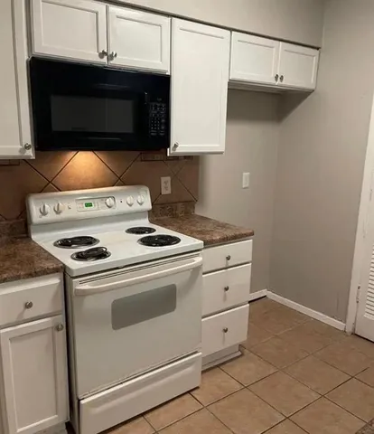 a stove top oven sitting inside of a kitchen