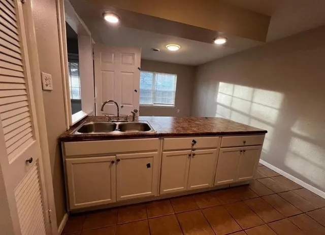 a kitchen with granite countertop a sink and cabinets