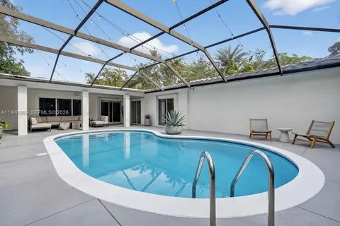 a view of a swimming pool with a table and chairs in the patio
