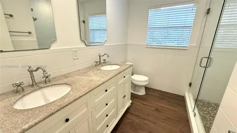 a bathroom with a granite countertop sink toilet and a mirror
