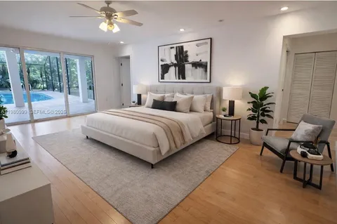 a bedroom with a large bed a chandelier and windows