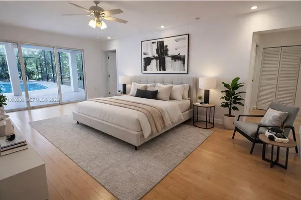 a bedroom with a large bed a chandelier and windows