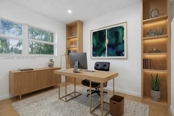 a view of a workspace with furniture and a window