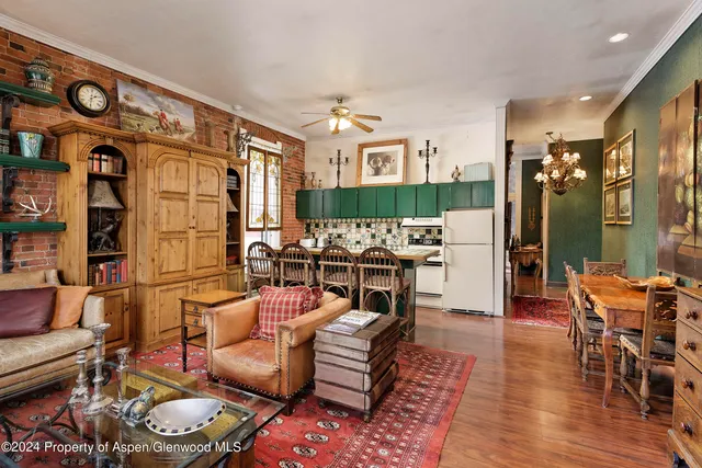 a living room with furniture kitchen view and a large window