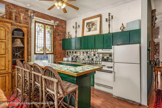 a kitchen that has a table chairs and a refrigerator