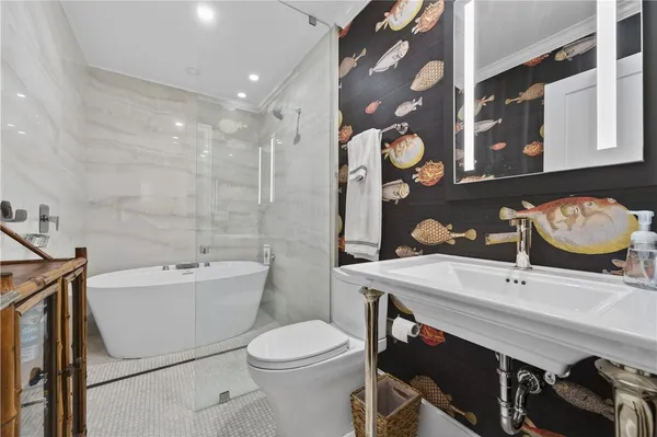 a bathroom with a sink a toilet and shower