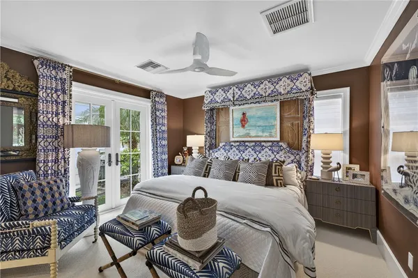 a bedroom with a bed a chandelier and large window