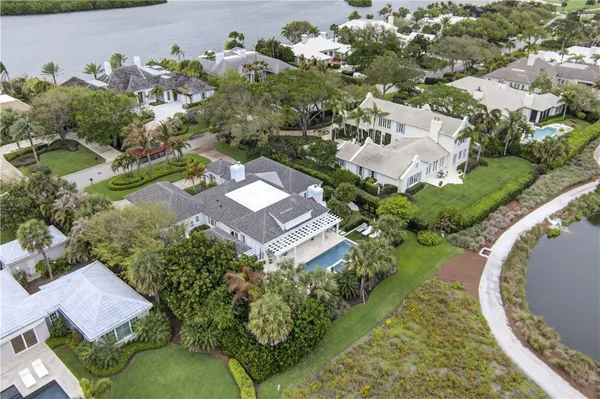 an aerial view of a house with a yard and lake
