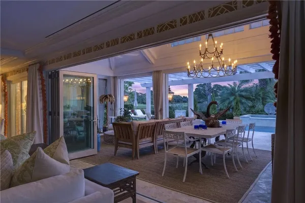 a view of a dining room with furniture a chandelier and wooden floor
