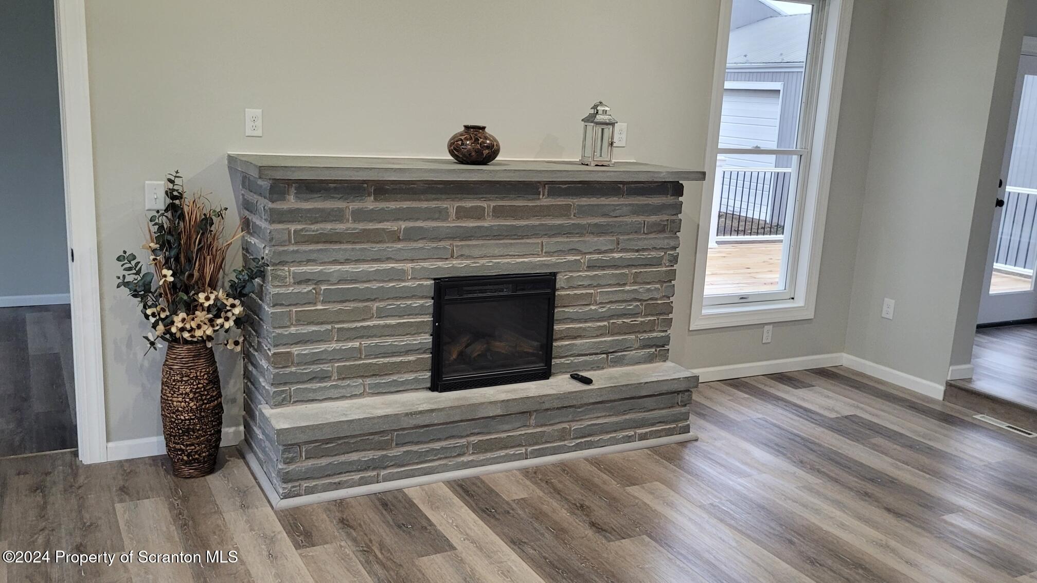 821 Mitchell Road Meshoppen, PA 18630 - Photo 34 of 58 a living room with a fireplace and potted plants