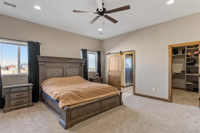 a bedroom with a bed a dresser and a chandelier