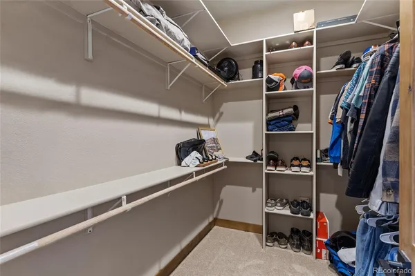 a view of walk in closet with clothes and shoes