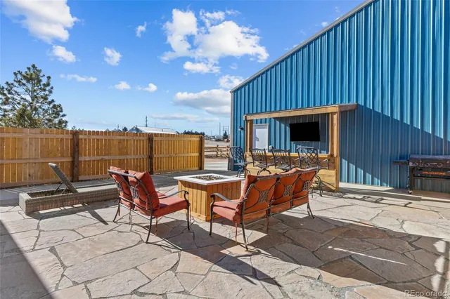 a roof deck with table and chairs