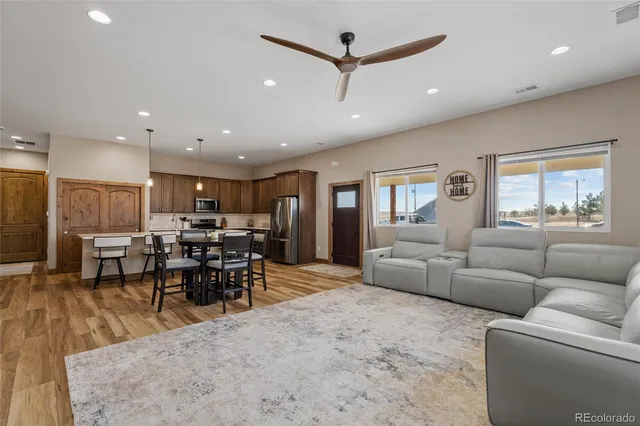 a living room with furniture and a dining table with kitchen view
