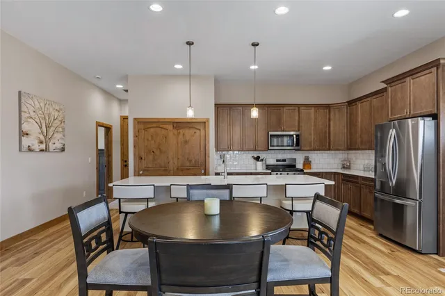 a kitchen with a table chairs refrigerator and microwave