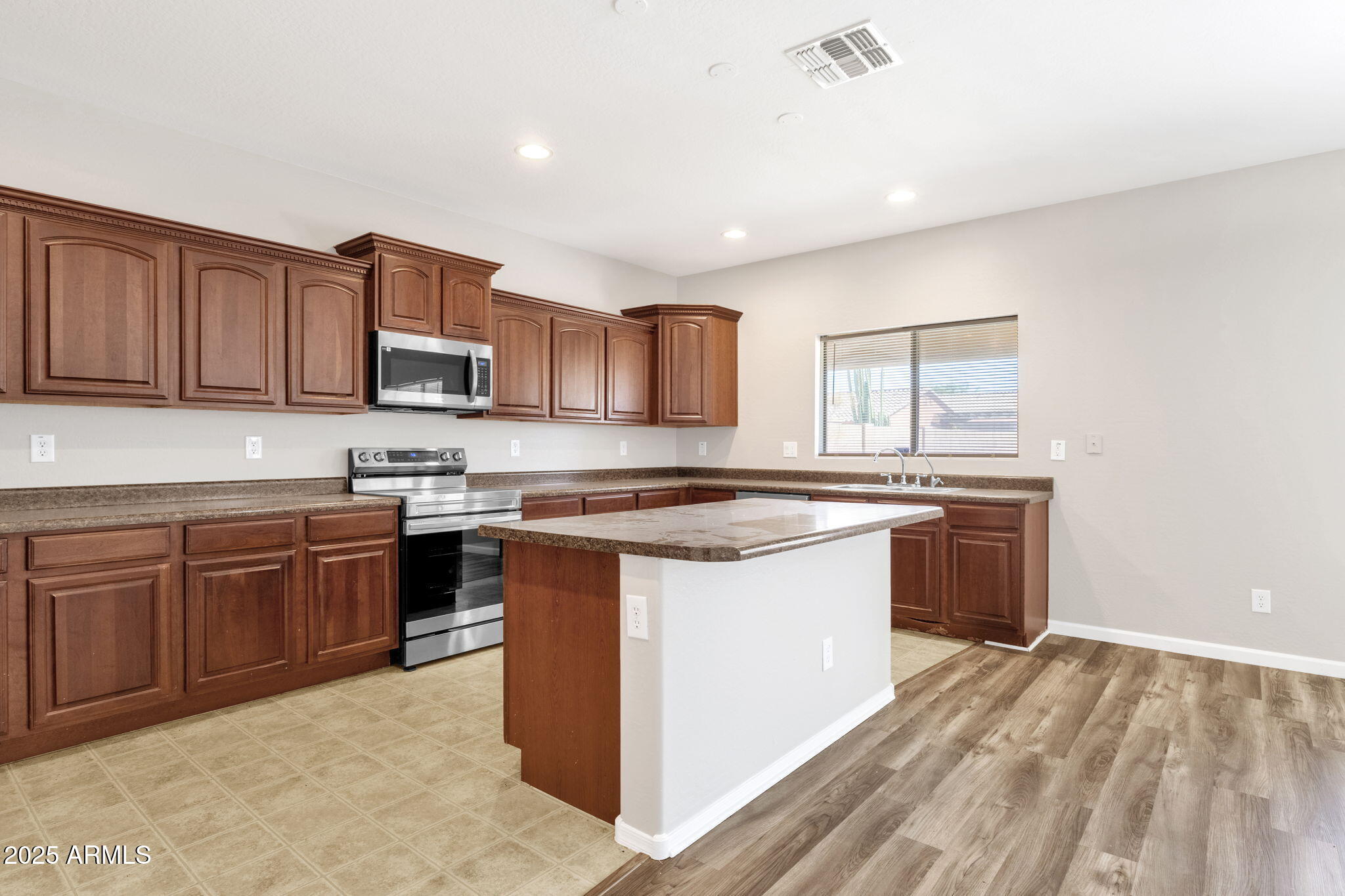 43003 West Magnolia Road Maricopa, AZ 85138 - Photo 13 of 32 a kitchen with stainless steel appliances granite countertop a stove a sink and a refrigerator