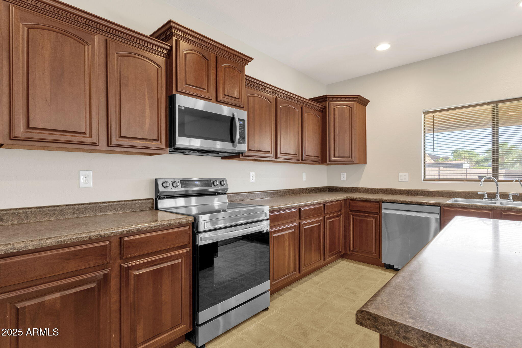 43003 West Magnolia Road Maricopa, AZ 85138 - Photo 14 of 32 a kitchen with stainless steel appliances granite countertop a sink stove and microwave