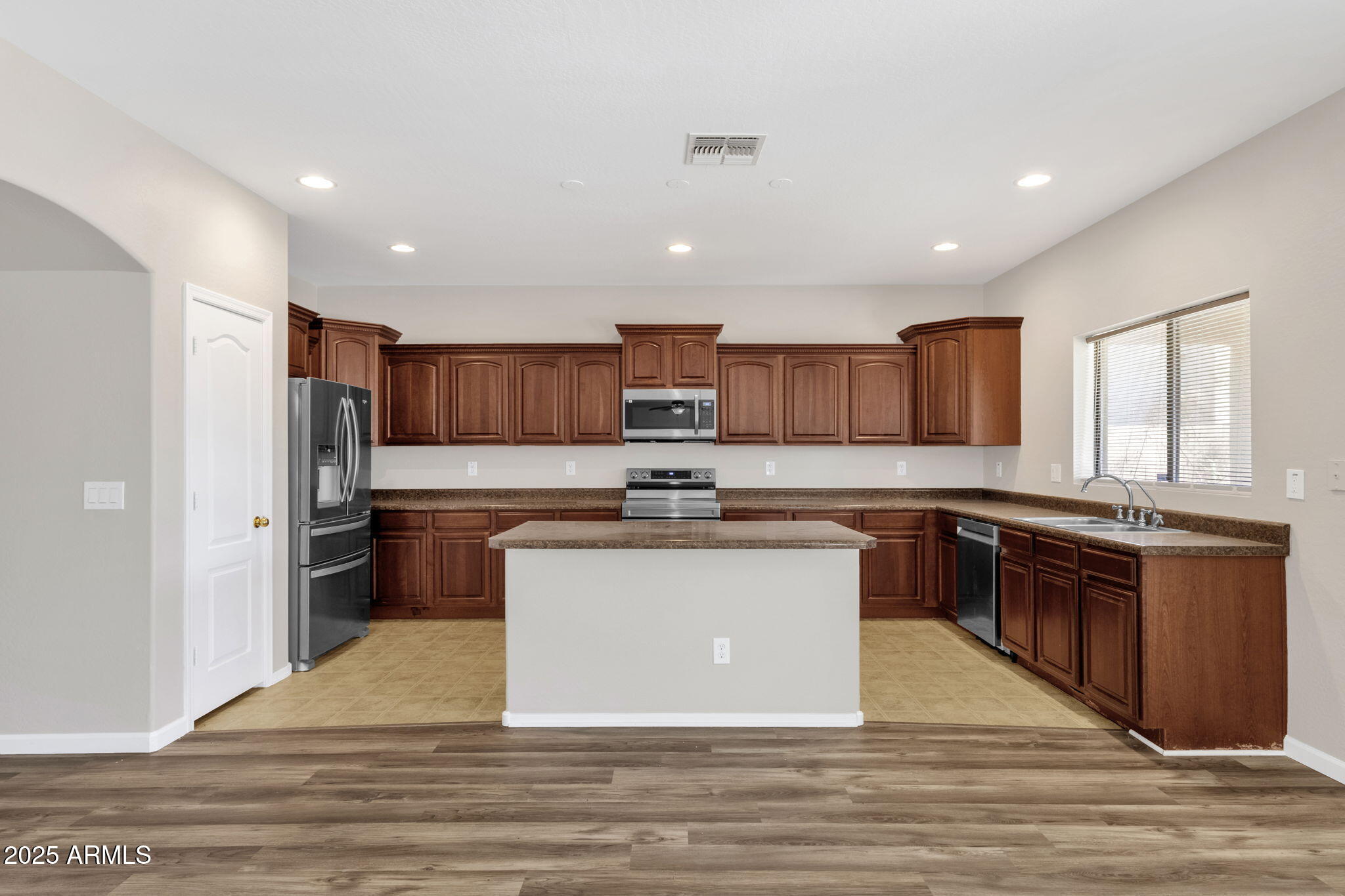 43003 West Magnolia Road Maricopa, AZ 85138 - Photo 15 of 32 a kitchen with stainless steel appliances granite countertop a stove top oven a sink and a refrigerator