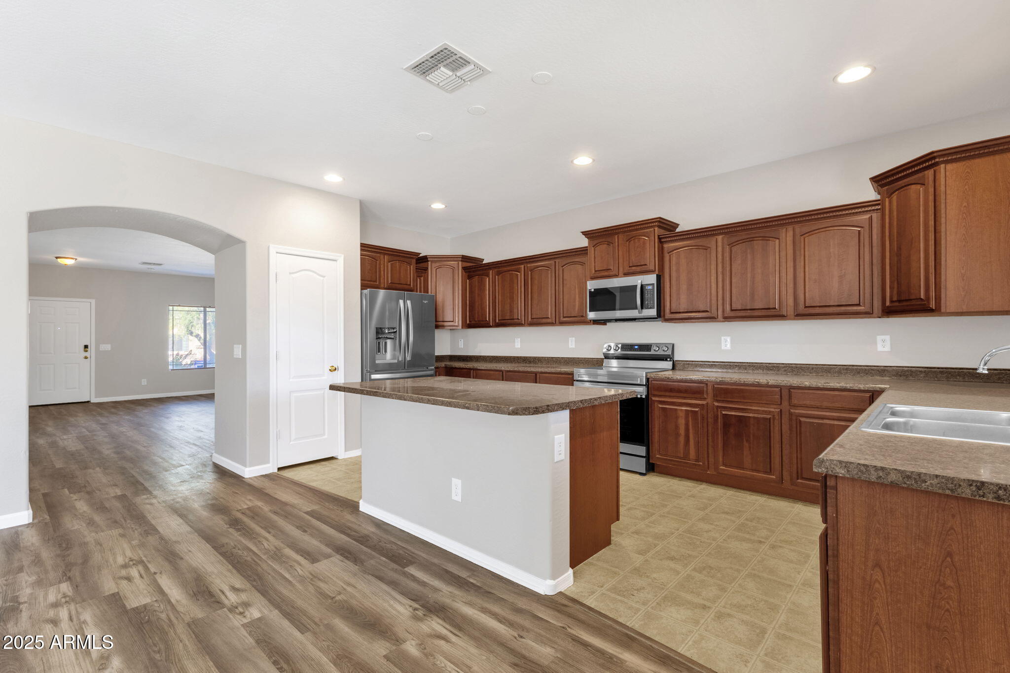 43003 West Magnolia Road Maricopa, AZ 85138 - Photo 16 of 32 a kitchen with stainless steel appliances granite countertop wooden cabinets a stove a sink and a oven