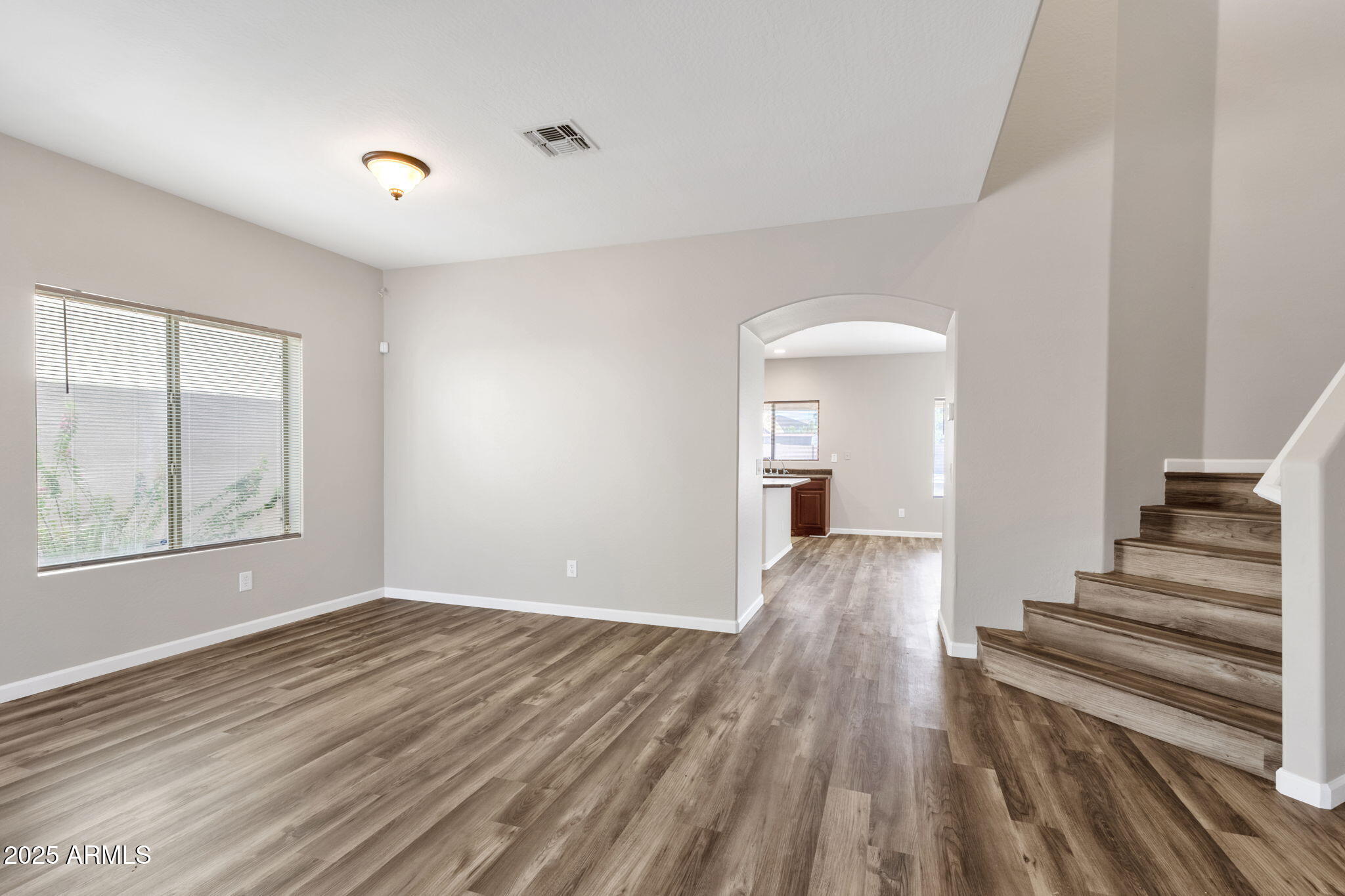43003 West Magnolia Road Maricopa, AZ 85138 - Photo 19 of 32 a view of an empty room with wooden floor and a window