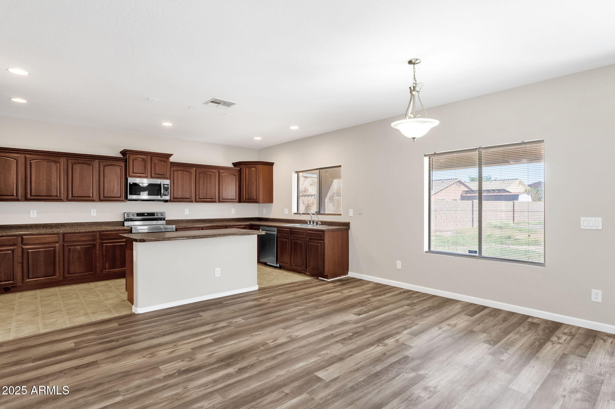 43003 West Magnolia Road Maricopa, AZ 85138 - Photo 20 of 32 a kitchen with stainless steel appliances granite countertop a sink counter space cabinets and a window