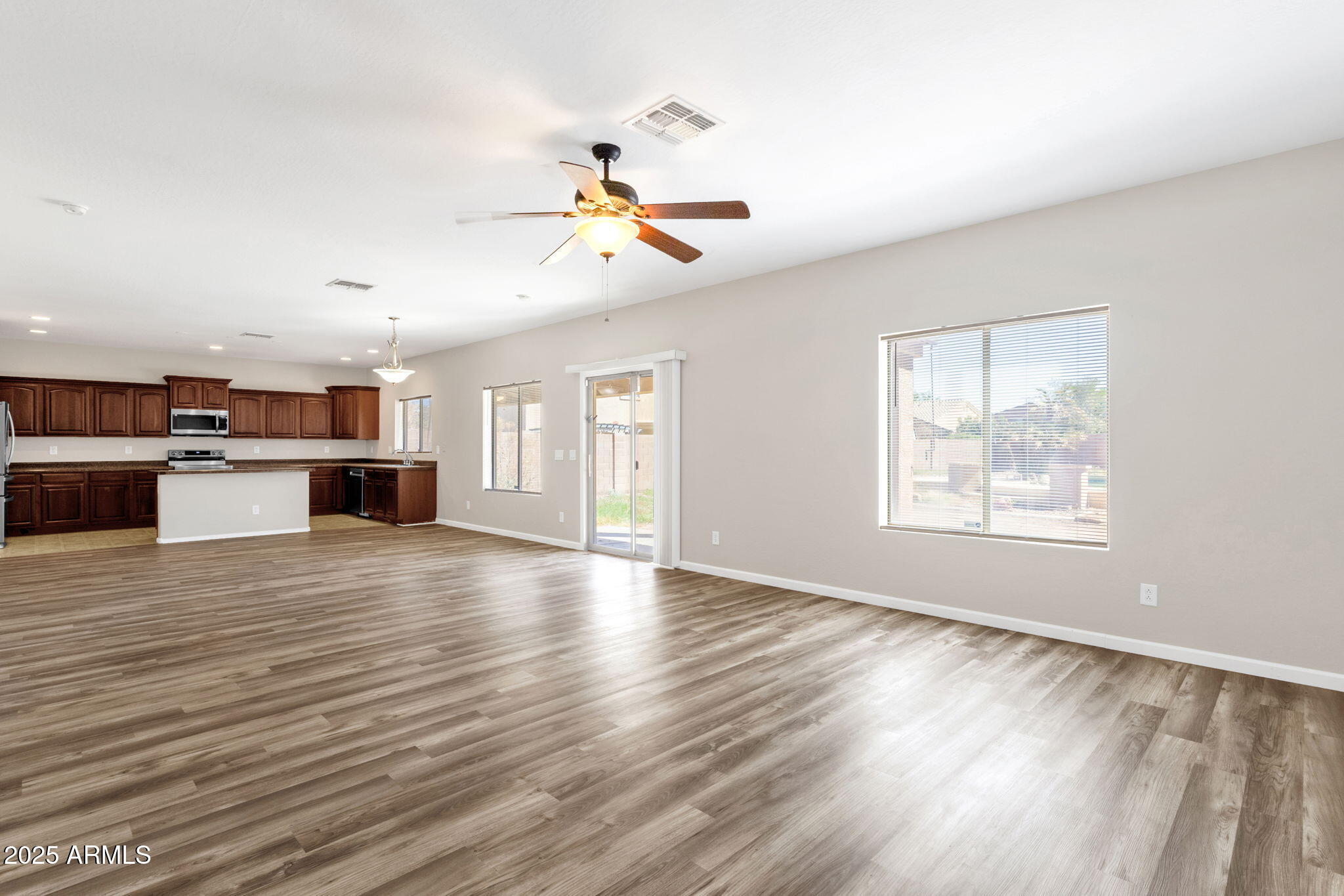 43003 West Magnolia Road Maricopa, AZ 85138 - Photo 2 of 32 wooden floor in an empty room with a kitchen