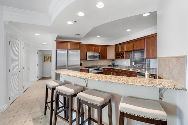 a kitchen with stainless steel appliances granite countertop a sink stove and refrigerator