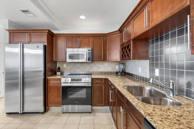 a bathroom with a granite countertop sink a mirror and a toilet