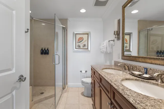 a bedroom with a large bed and a chandelier fan