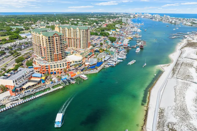 a living room with couch and a dining table with wooden floor