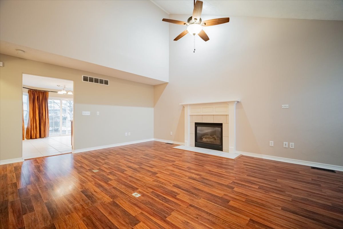 2885 East Raab Road Normal, IL 61761 - Photo 5 of 35 a view of empty room with wooden floor and fireplace