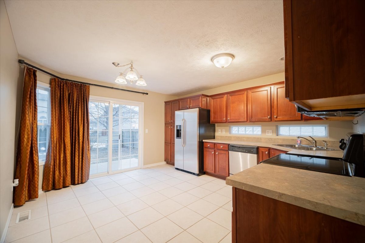 2885 East Raab Road Normal, IL 61761 - Photo 8 of 35 a kitchen with stainless steel appliances granite countertop a refrigerator a sink dishwasher and wooden cabinets with wooden floor